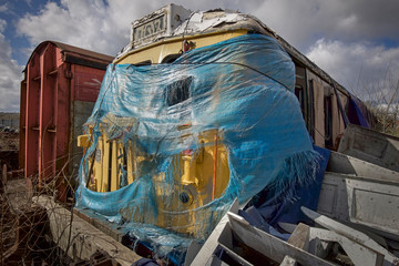 Mothballed dead train engine with failing protective cover