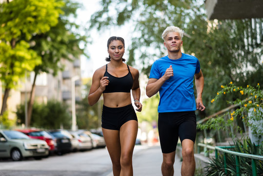 Healthy young couple jogging outdoors