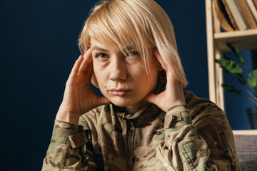 Close up portrait of young female soldier. Woman in military uniform on the war. In doctor's consultation, depressed and having problems with mental health and emotions, PTSD, rehabilitation.