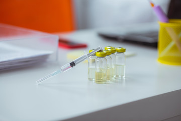 Close up of medical syringe lying on ampoules with antibiotic