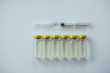 Medical syringe lying above six ampoules with antibiotic