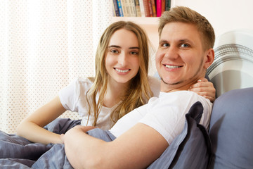 Happy loving couple in the bedroom in the morning . Family couple people concept.