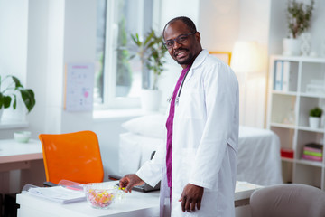 Medical scientist wearing white jacket standing near working table
