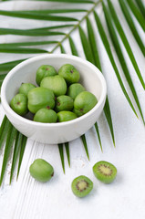 Mini kiwi on a white plate. Small exotic fruits on white background.