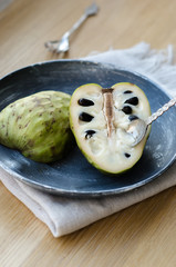 Cherimoya on the black plate on a wooden table