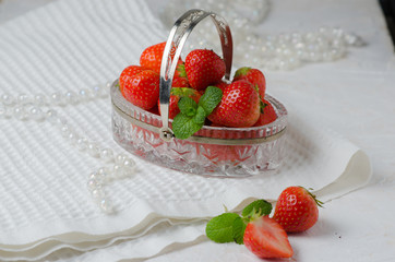 Heap of fresh strawberries in in a crystal basket on white background. Places for text. Postcard