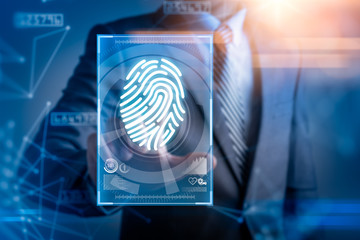 The abstract image of the businessman use a thumb scanning overlay with futuristic hologram. the concept of fingerprint, biometric, information technology and cyber security.