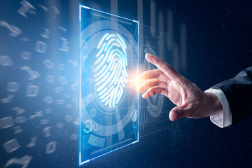 The abstract image of the businessman use a thumb scanning overlay with futuristic hologram. the concept of fingerprint, biometric, information technology and cyber security.