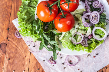 Fresh fragrant salad with tomatoes, cucumbers, onions, parsley, dill and lettuce leaves. Vegetarian...