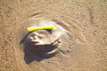 Geometric face on the beach sand