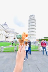 Hand Holding Gelato with the Leaning Tower of Pisa as Background