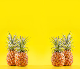 Beautiful fresh pineapple isolated on bright yellow background, summer seasonal fruit design idea pattern concept, copy space, close up