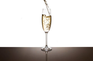 Champagne is poured into glasses on a white background