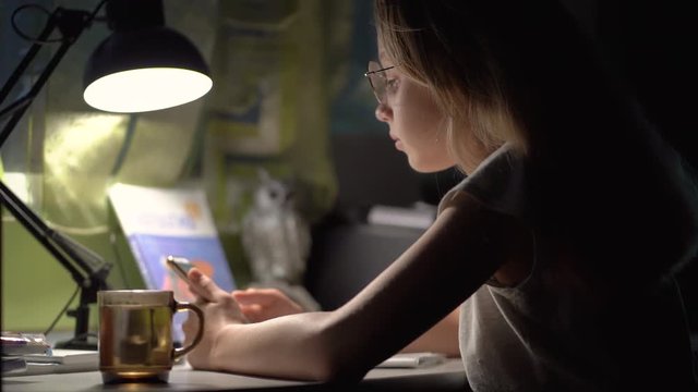 Girl Writing Homework in Night Internet Usage, Girl doing complicated math homework and drinking hot tea. Slow motion video