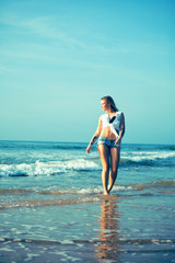 young pretty blond woman at seacoast walking relaxing, fashion lady at sunset, cool vacations