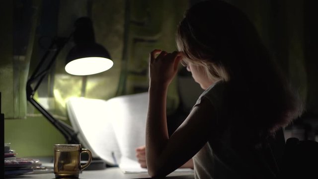 Girl Writing Homework in Night Internet Usage, Girl doing complicated math homework and drinking hot tea. Slow motion video