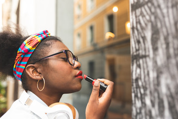 Afro American Girl Applying Make Up Outdoors.