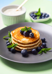 Stack of home made pancakes served with fresh berries and maple syrup. Simple and delicious breakfast