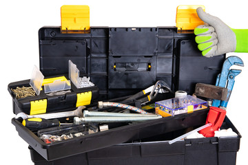 Plumber or carpenter tool box isolated. Black plastic tool kit box with assorted tools and with various nails, screws, fasteners as well as dowels isolated on a white background.