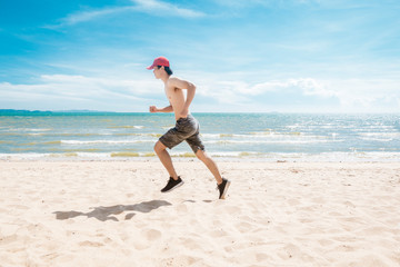 Muscular man is running on the beach