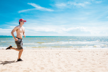 Muscular man is running on the beach