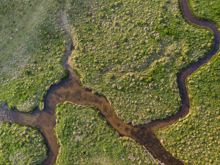 Stunning aerial drone landscape image of meandering river through marshland at sunrise