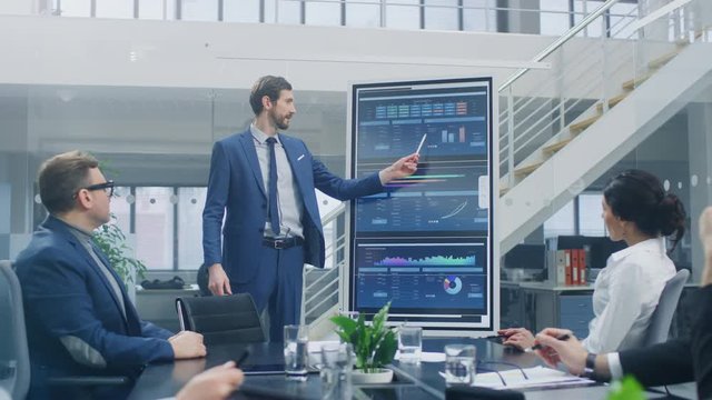 In the Corporate Meeting Room: Ambitious Executive Uses Digital Interactive Whiteboard for Presentation to a Board of Directors Lawyers Investors. Screen Shows Company Growth Data with Animated Graphs
