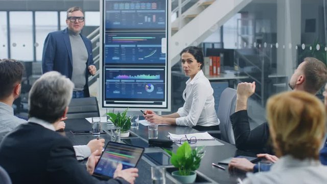 In the Corporate Meeting Room: Creative Director Uses Digital Interactive Whiteboard for Presentation to a Board of Executives, Lawyers, Investors. Screen Shows Company Growth Data with Animated Graph