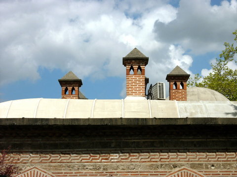 Nebengeb&auml;ude der Gro&szlig;en Moschen mit kleinen T&uuml;rmen vor blauem Himmel mit Wolken bei Sonnenschein in der alten osmanischen Hauptstadt Bursa am Uludag Gebirge in der T&uuml;rkei
