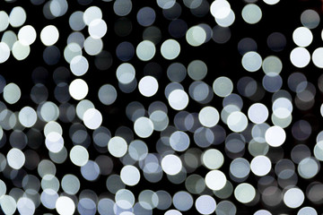 Unfocused abstract white bokeh on black background. defocused and blurred many round light