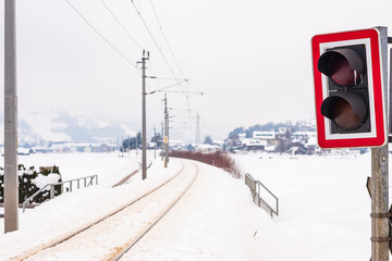 Railway-road crossing and the snow-covered fields in a scenic winter mountain landscape, Dachstein massif, Liezen District, Styria, Austria, Europe