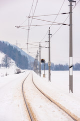 Railway power lines and the snow-covered fields in a scenic winter mountain landscape, Dachstein massif, Liezen District, Styria, Austria, Europe
