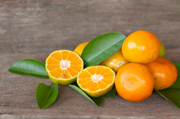  Ripe oranges and leaves on a wooden table, separate on the old wooden floor, sour fruit
