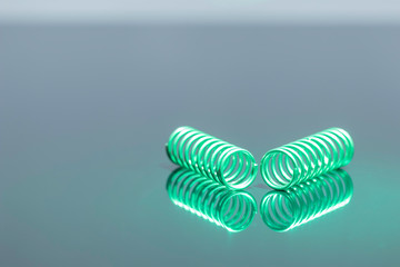 グレーを背景に緑のスプリング、らせんのリフレクト