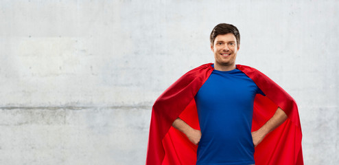 super power and people concept - happy young man in red superhero cape over grey concrete background
