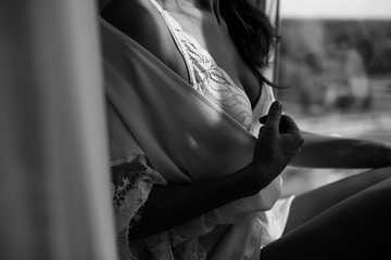 Beautiful young girl in white underwear posing near the window