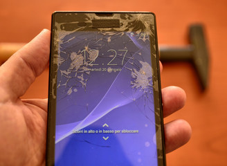 Close up on a smartphone screen with a broken screen and a thousand cracks