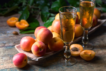 Apricots  and glasses of apricot liqueur old wooden table.