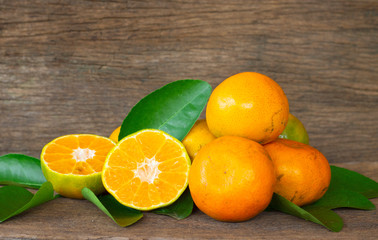  Ripe oranges and leaves on a wooden table, separate on the old wooden floor, sour fruit