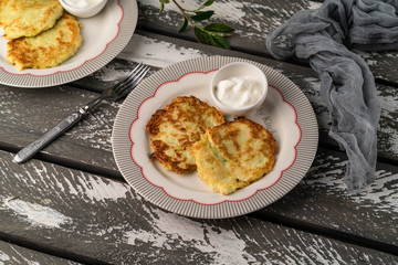 pancakes and sour cream, on a wooden rustic backdrop