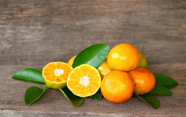  Ripe oranges and leaves on a wooden table, separate on the old wooden floor, sour fruit