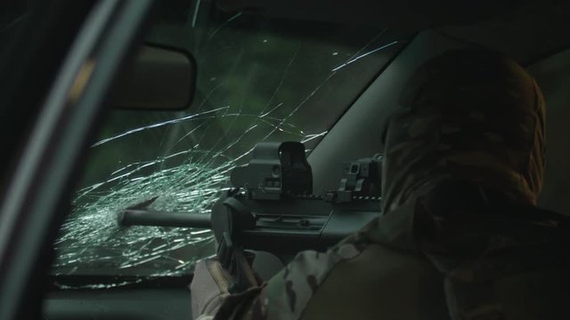 Shooting from a car, a rifle with a silencer. Rifle shooting. Fully equipped sniper. Secret mission, Operation in Action. Slow Motion. 4K. UHD.