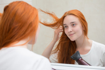Fototapeta premium a young woman is drying her hair