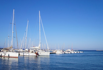 Fototapeta na wymiar Yacht club with snow-white ships on the pier in the lagoon in the port.