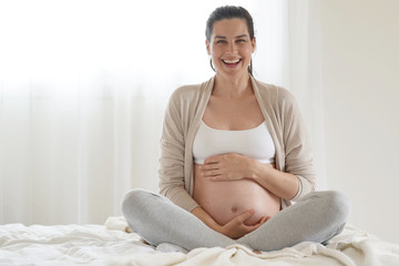 Portrait of pregnant woman relaxing in bed