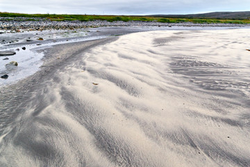 Patterns of black and yellow sand in the tidal zone on the beach of the North Sea
