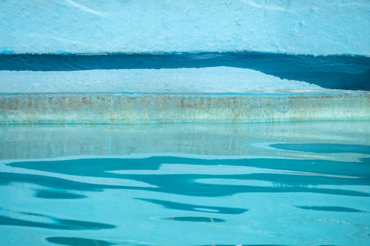 Edge of blue swimming pool with rippled water