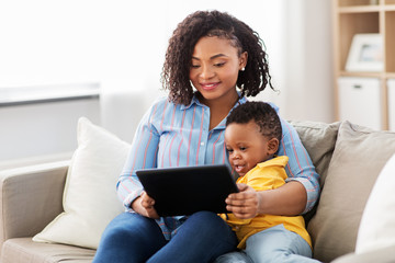 family, motherhood and technology concept - happy african american mother using tablet computer with little baby son at home - Powered by Adobe