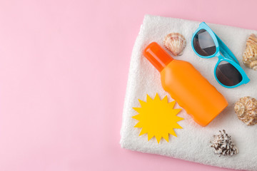 Sunscreen and paper sun and summer accessories on a bright pink background. summer. vacation. Sun protection. top view. space for text
