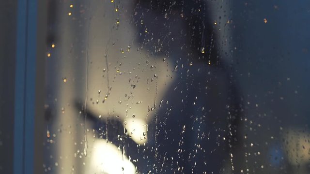 Woman connecting with her phone next to a window